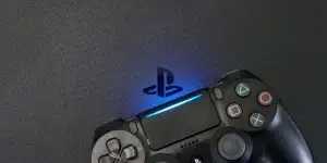 Sony PlayStation 4 Slim (PS4) with DualShock 4 controller shining blue LED on logo
