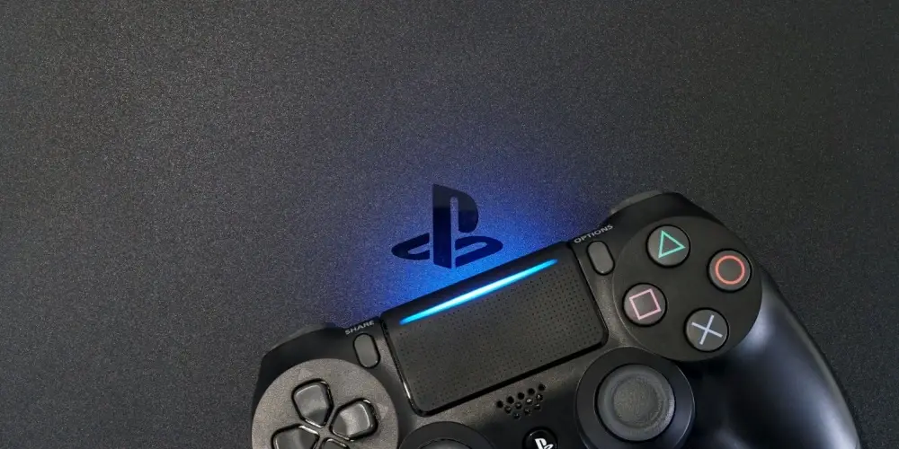 Sony PlayStation 4 Slim (PS4) with DualShock 4 controller shining blue LED on logo