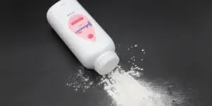Jonhson & Jonhson baby talcum powder bottle with some talc coming out of the bottle