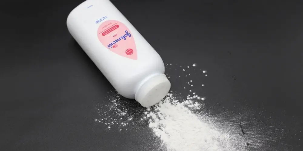 Jonhson & Jonhson baby talcum powder bottle with some talc coming out of the bottle