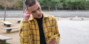 Young non binary person checking his smartphone worried.