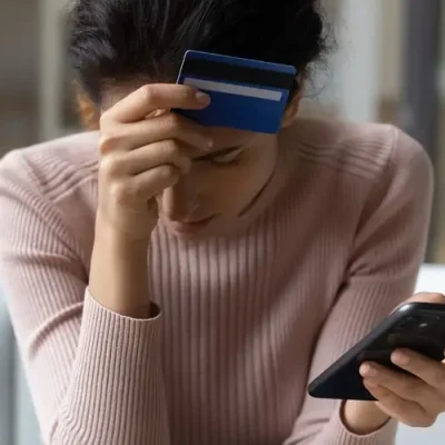 Frustrated young woman having lost savings due to app fraud.