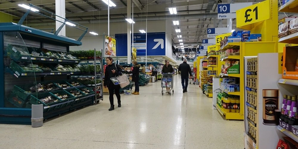 Shoppers browse an aisle in a Tesco supermarket