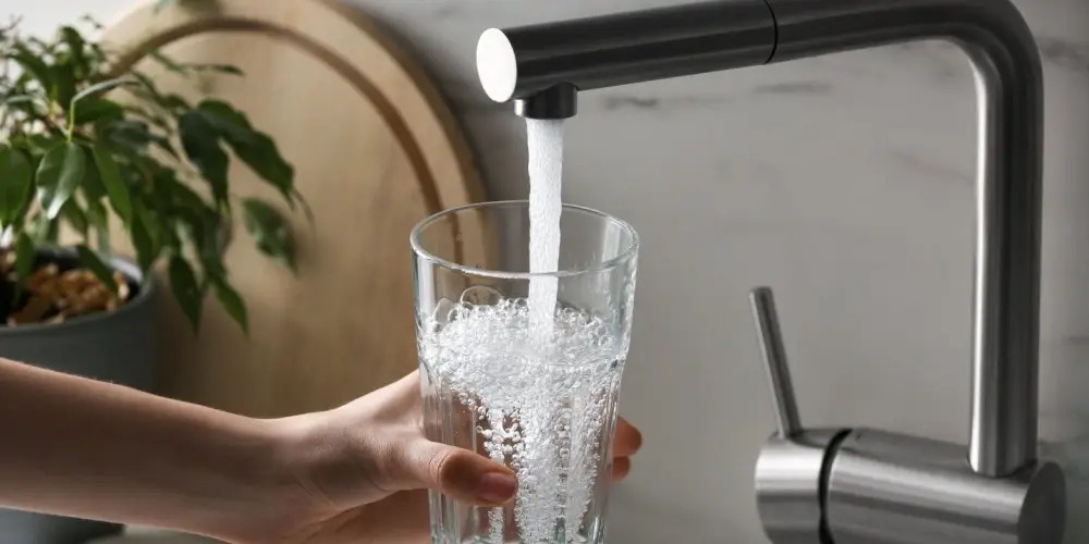 A woman filling up a glass with tsp water