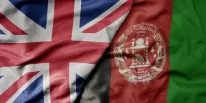 big waving national colorful flag of great britain and national flag of afghanistan