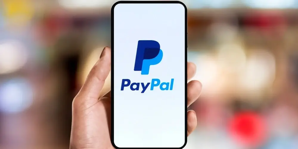 hand holding phone with PayPal apps on the screen.