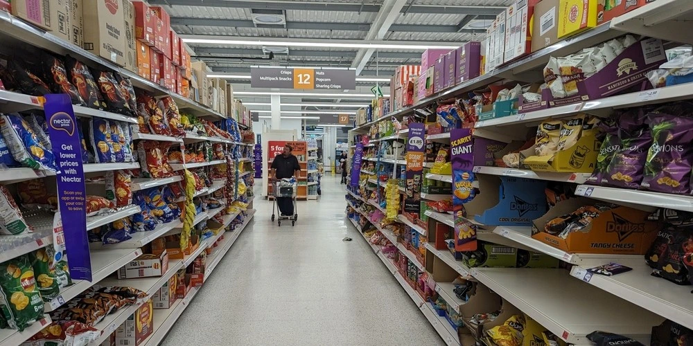An aisle with shelves of potato snacks is seen in a Sainsburys supermarket