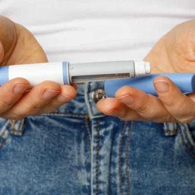 Semaglutide Injection pen closeup. Semaglutide or insulin drug against female belly.