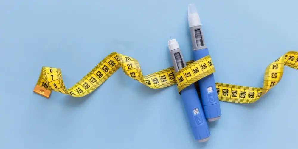 Two injectors dosing pens for subcutaneous injection of antidiabetic medication or anti-obesity medication hovering over a blue background. Yellow measuring tape around the injectors. antidiabetic