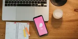 Working wooden table with Flo logo on the phone screen